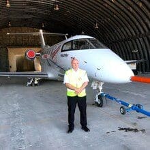 Security guard protecting area around a aircraft within a aircraft hanger at a private runway.