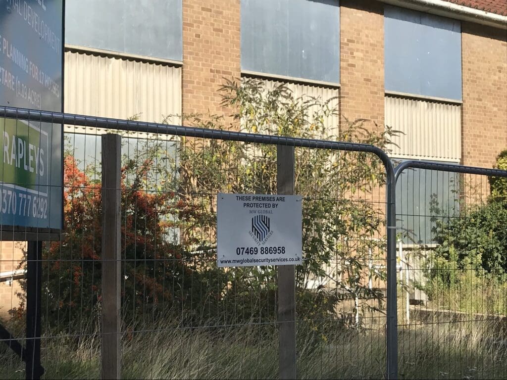 Vacant commercial property protected by MW Global security signage and perimeter security