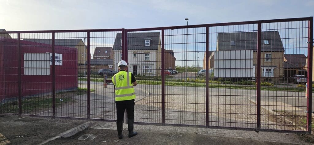 Construction site security guarding Bury St Edmunds, MW Global Security guard locking site main access gate.