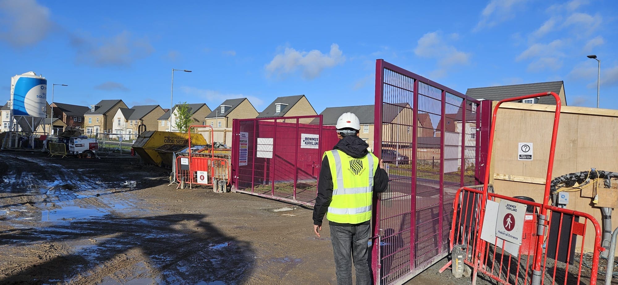MW Global Security guard managing access control on a construction site.