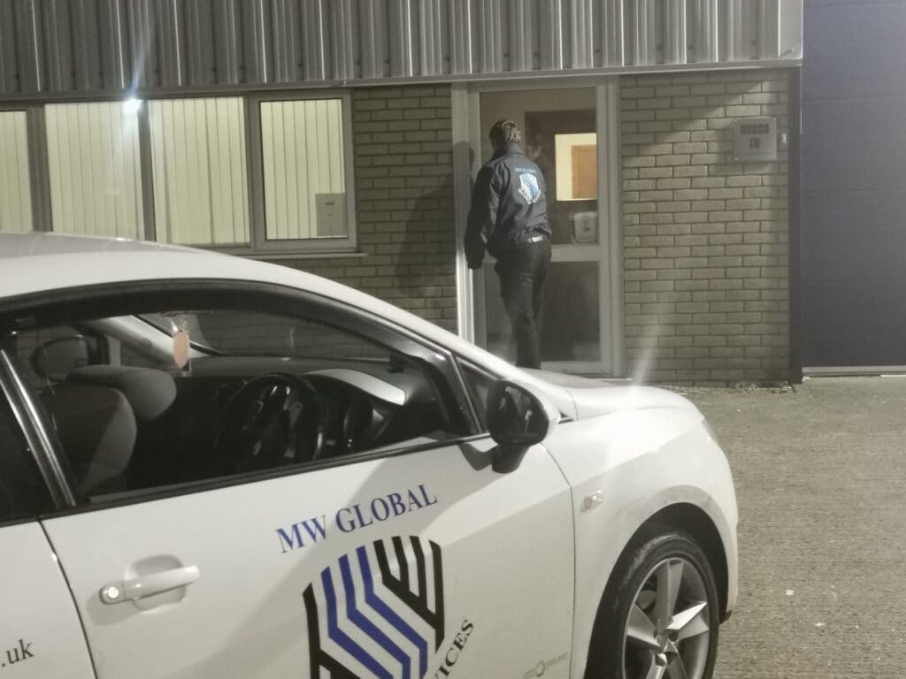 MW Global mobile patrol officer checking a commercial building entrance at night